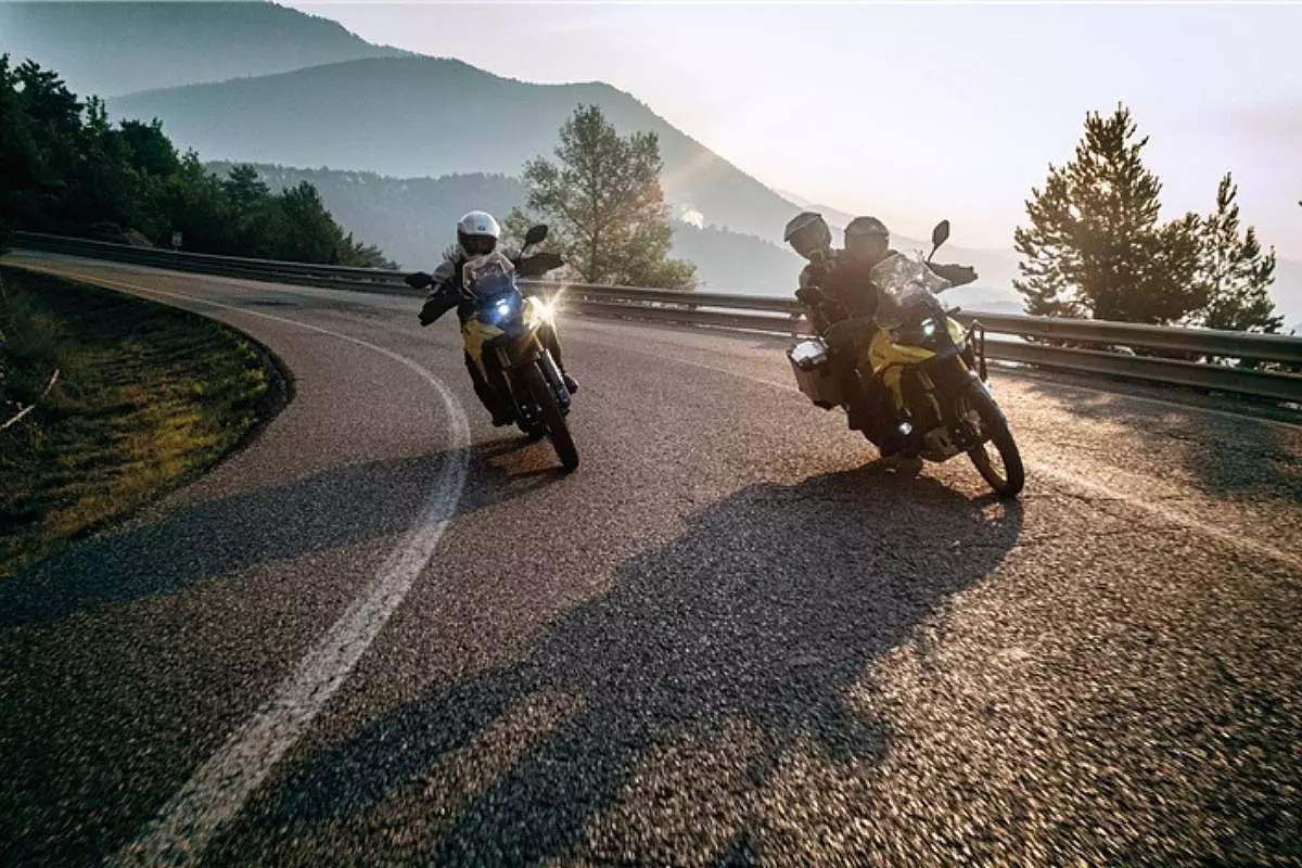 Motociclette guidate Suzuki V-Strom 800 DE, su un tornante di montagna