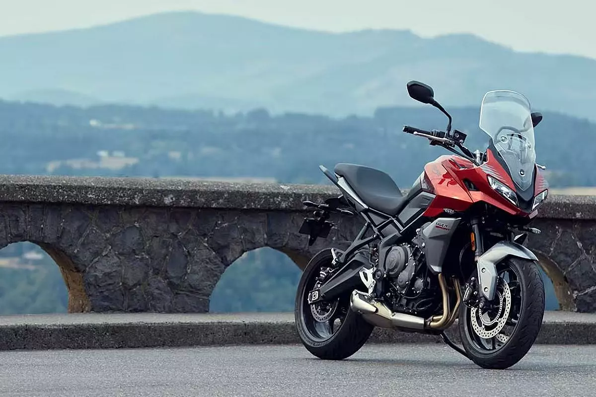 Motocicletta Triumph Tiger Sport 660 con dietro un panorama ed un ponte