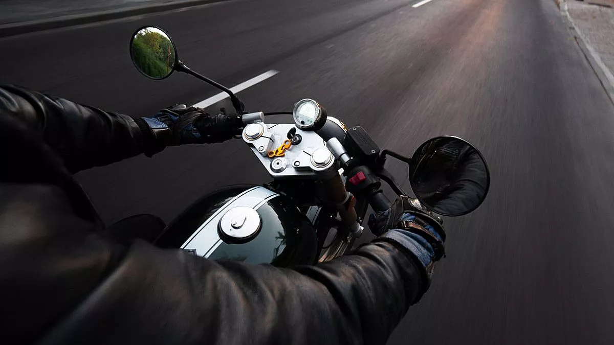 Motociclista che guida su autostrada con una giacca nera