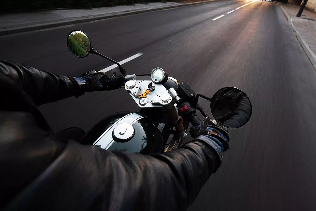 Motociclista che guida su autostrada con una giacca nera