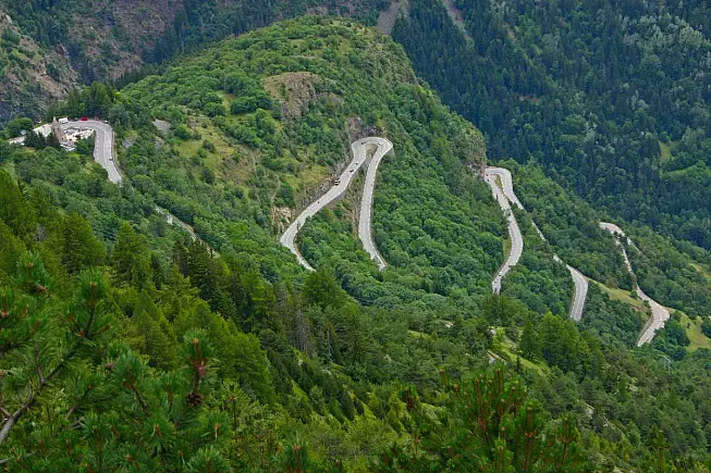 Alpe d'Huez. Vista dei tornanti e della Église Saint-Ferréol. iStock-537525106