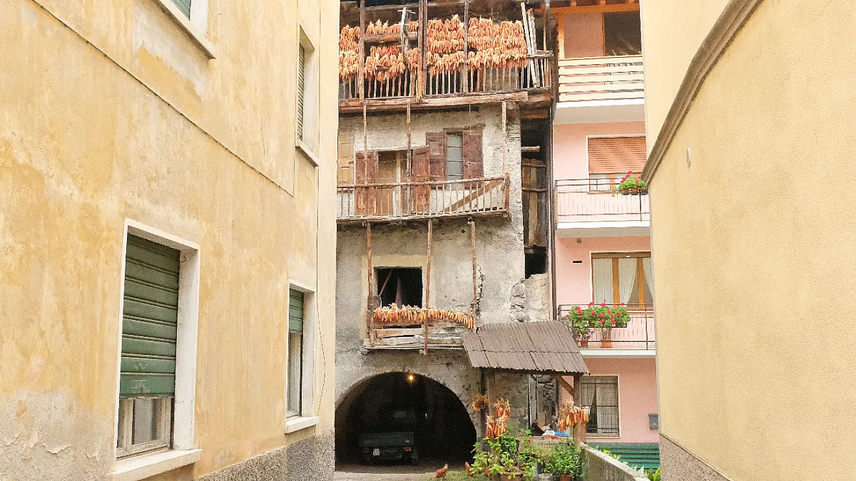 Case di Storo, in Trentino-Alto Adige, con le tipiche pannocchie appese ad essiccare sui balconi. Shutterstock_1565872798